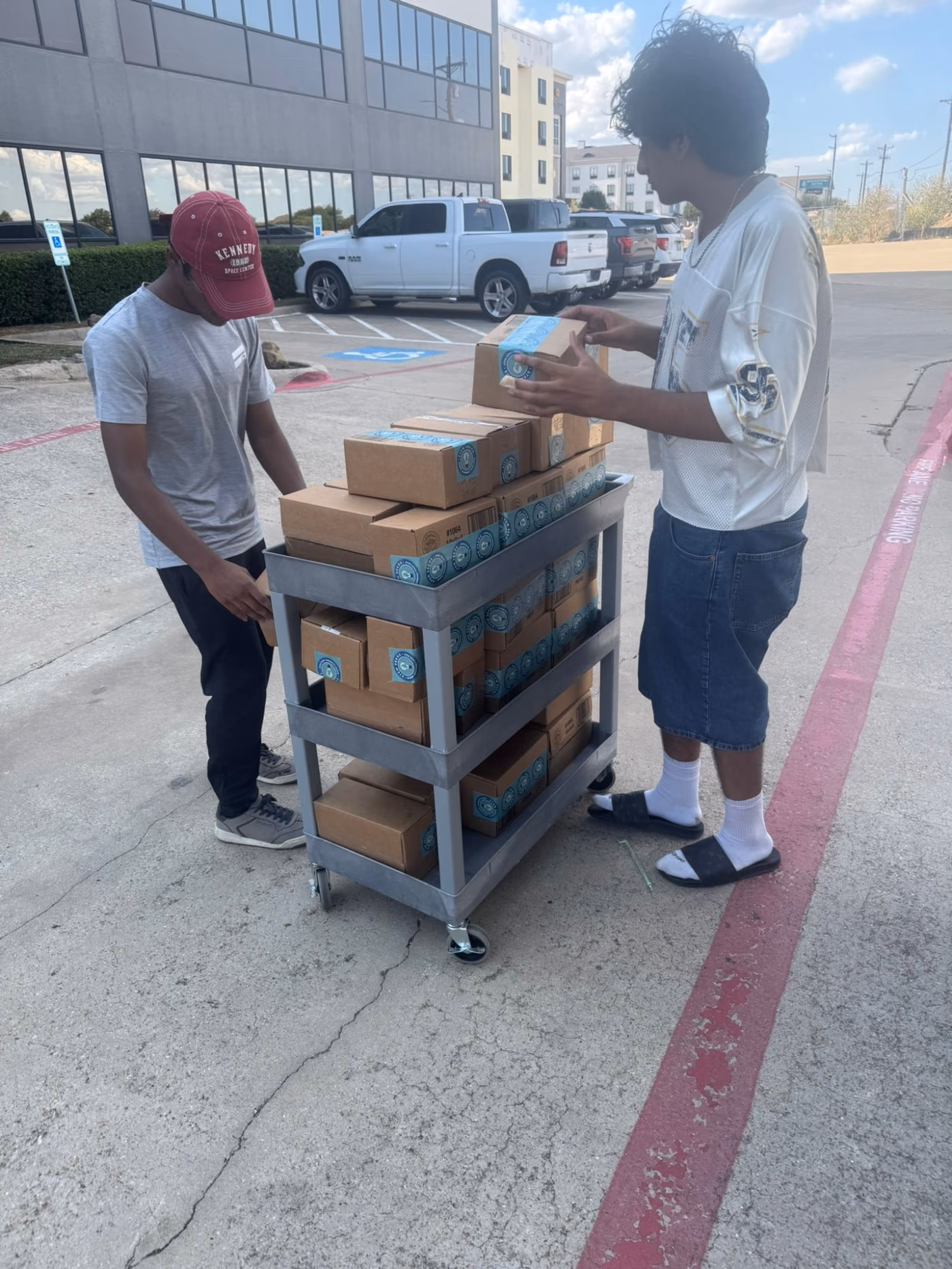 Two chapter members loading a cart full of sealed STEMKit boxes