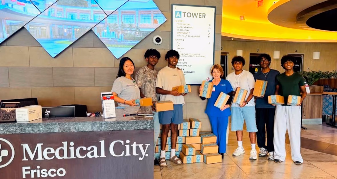 Chapter members and Medical City staff holding STEMKits in the Medical City Frisco lobby