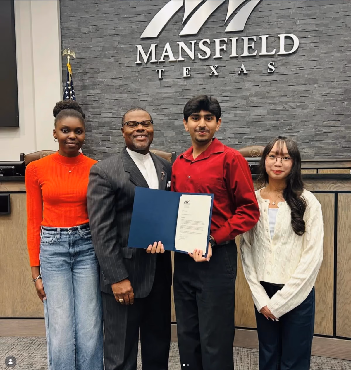Mansfield chapter members and a city official holding the Certificate of Recognition in the Mansfield council chambers