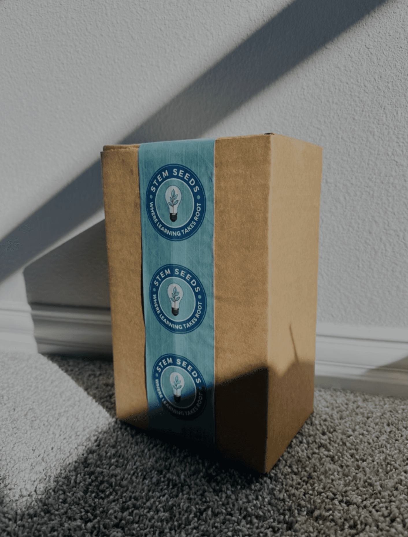 A sealed STEMKit box wrapped in Where Learning Takes Root tape